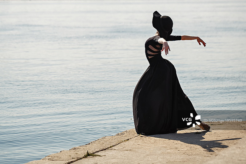 芭蕾舞者戴着帽子，穿着黑色长裙，跳着美丽的舞蹈。图片素材