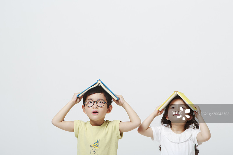 两个孩子把书举过头顶图片素材