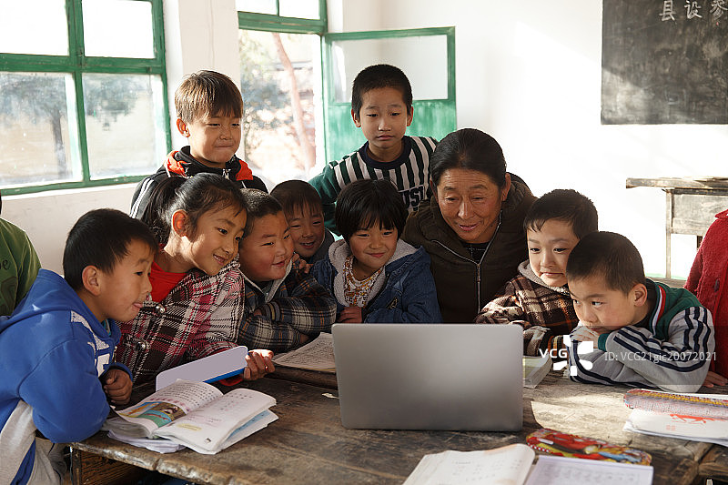 乡村女教师和小学生在使用电脑图片素材