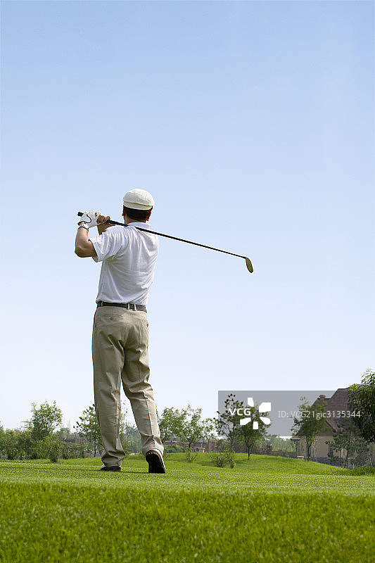 挥杆的高尔夫男球手图片素材