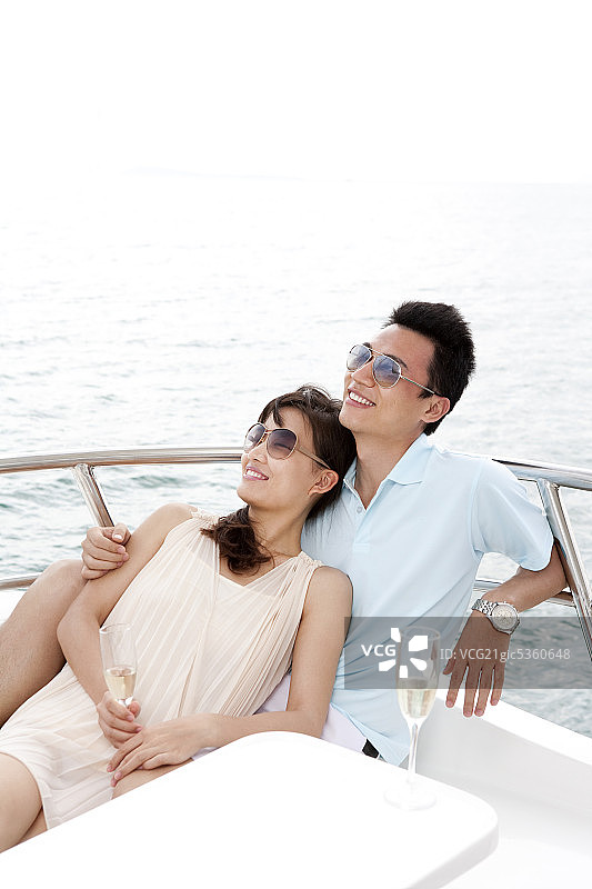 青年夫妇在游艇上喝香槟图片素材
