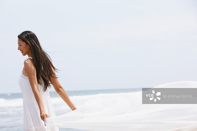 沙滩上穿着白布白裙子的女人图片素材