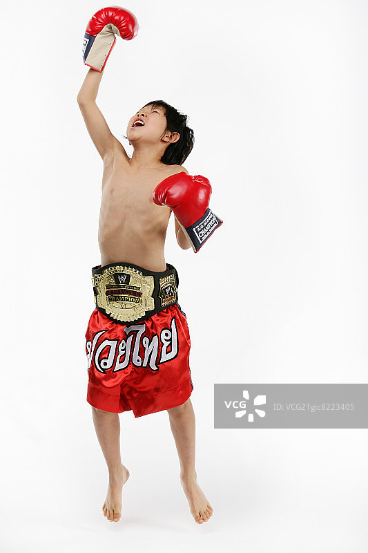 男孩(12-13岁)戴着拳击手套和冠军腰带，在半空中跳跃，肖像，特写图片素材