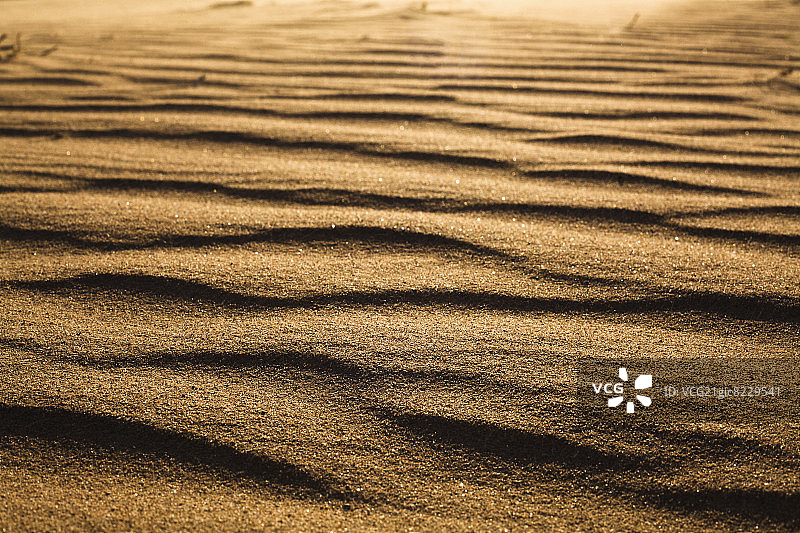地面水平拍摄的沙漠和风在沙子上的模式图片素材