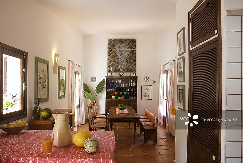 开放式的室内与长餐桌和陶器在现代梳妆台下面墙上的现代画图片素材