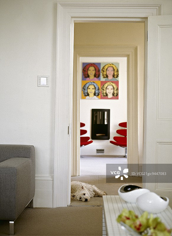 透过两个门道-客厅的冷色与明亮的红色设计师椅子下流行艺术图片对比图片素材