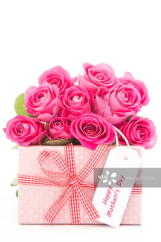 一束美丽的粉红色玫瑰旁边的粉红色礼物与一个快乐的母亲节贺卡在白色的背景接近图片素材