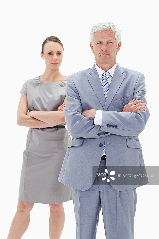 严肃的商人身后有个女人双手交叉，背景是白色图片素材