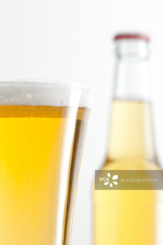 在白色的背景下，装满啤酒的玻璃杯和瓶子图片素材