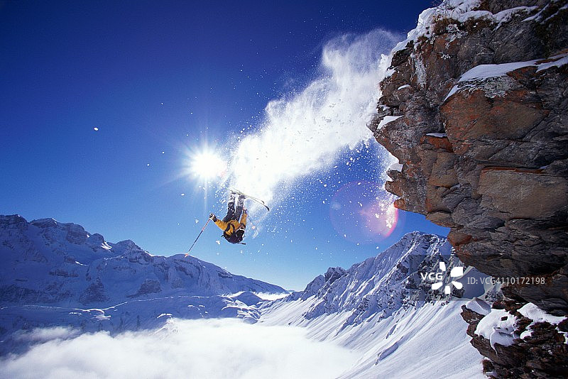 男滑雪者飞离岩石图片素材