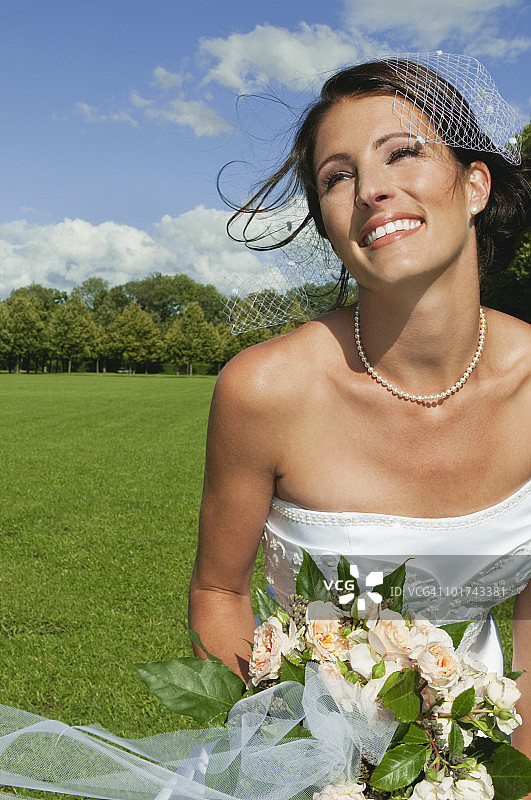 德国，巴伐利亚，新娘在公园里拿着一束花，特写图片素材