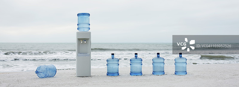 饮水机和水罐在海滩上排成一排图片素材