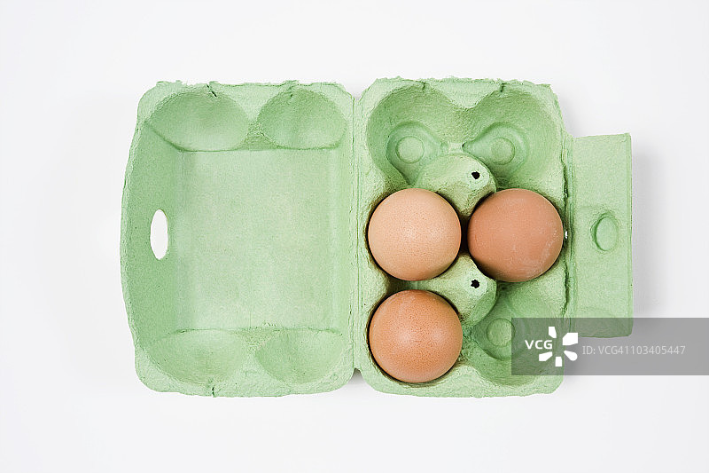 三个棕色的鸡蛋装在一个装鸡蛋的纸盒里图片素材