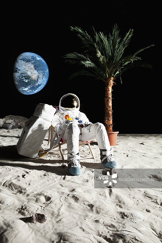 一个宇航员在月球上的沙滩椅上休息图片素材