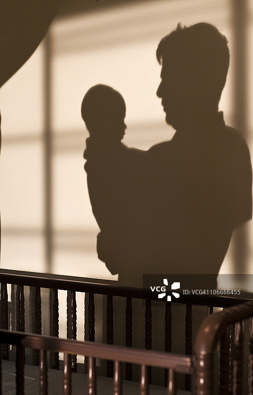 父亲和儿子的影子在婴儿床附近图片素材