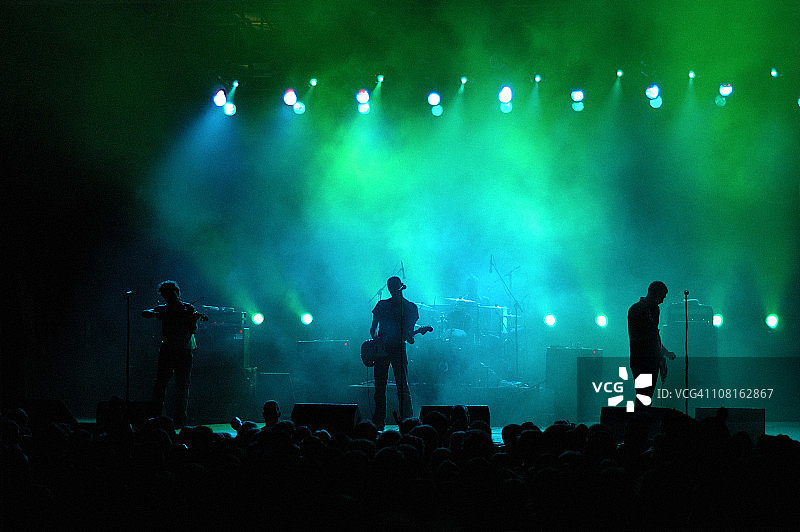 彩色灯光下舞台上乐队的剪影图片素材