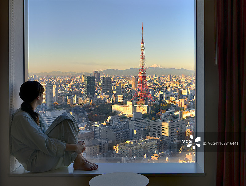 年轻女子看日出的东京图片素材