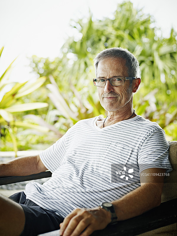 一个坐在热带度假胜地的成熟男子的肖像图片素材