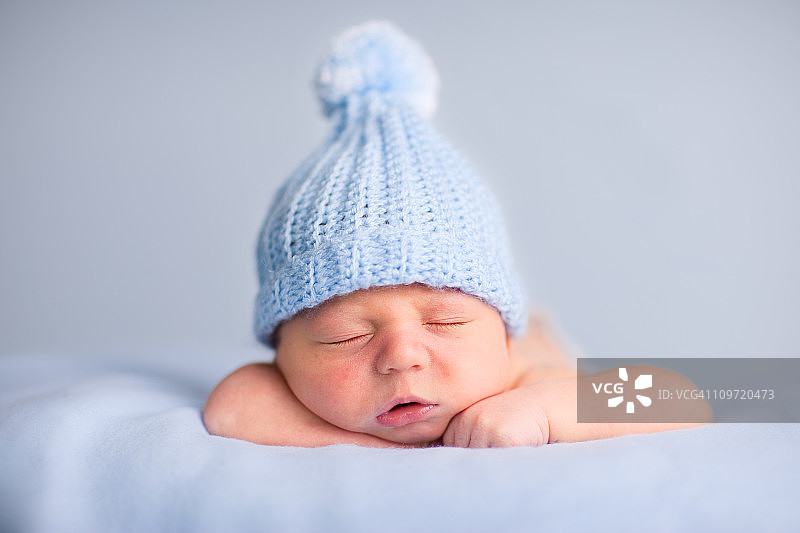 新生男婴戴着针织帽平静地睡觉图片素材