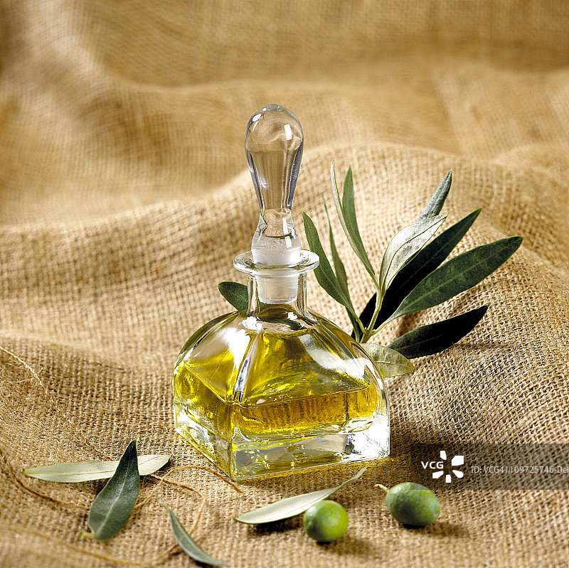 绿橄榄和橄榄油在麻袋布上图片素材