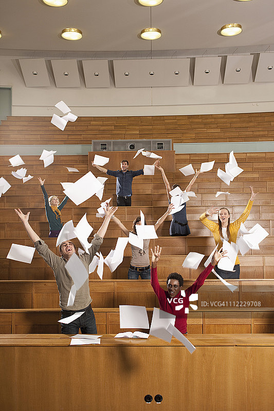 德国，莱比锡，一群大学生在教室里扔纸图片素材