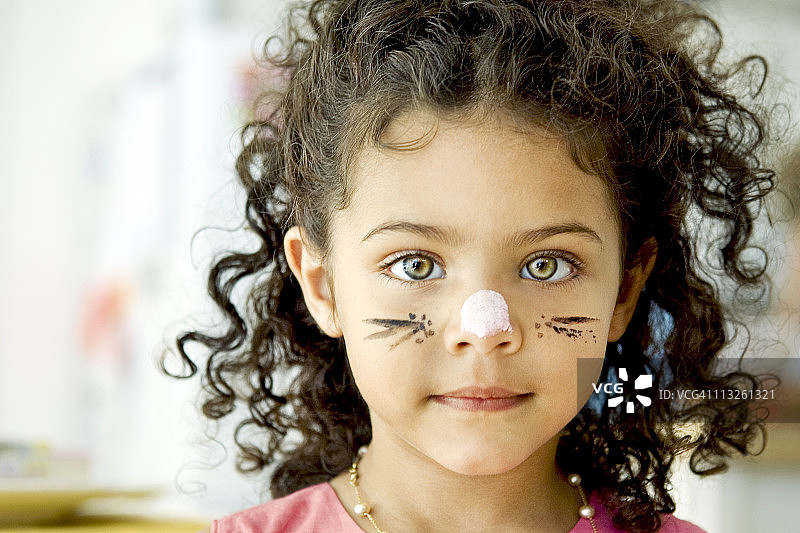 一个四岁的女孩，脸上涂了油彩图片素材