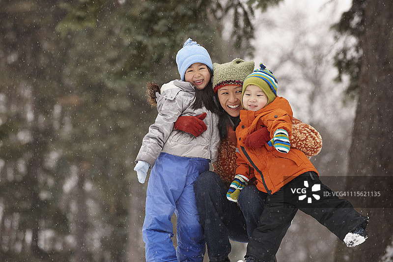 中国母亲在雪中拥抱孩子图片素材