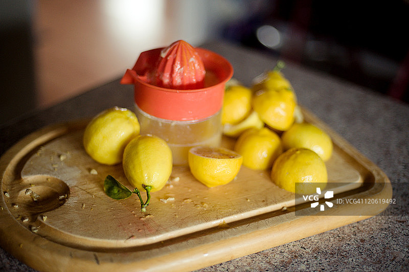 在切菜板上的柠檬汁旁边切柠檬图片素材