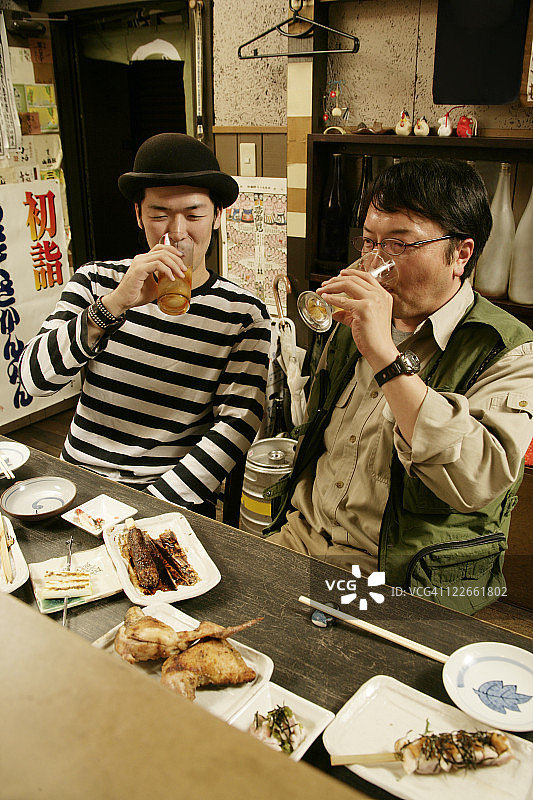 在日式酒吧里喝啤酒的男人图片素材