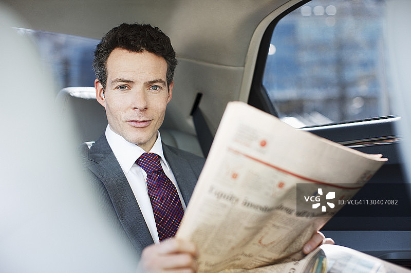 政客在汽车后座上看报纸图片素材