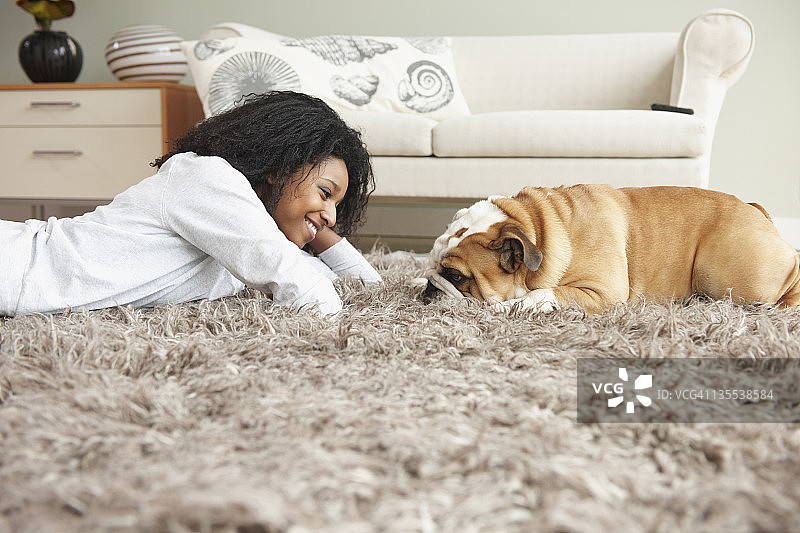一个黑人妇女和一只狗躺在地板上图片素材