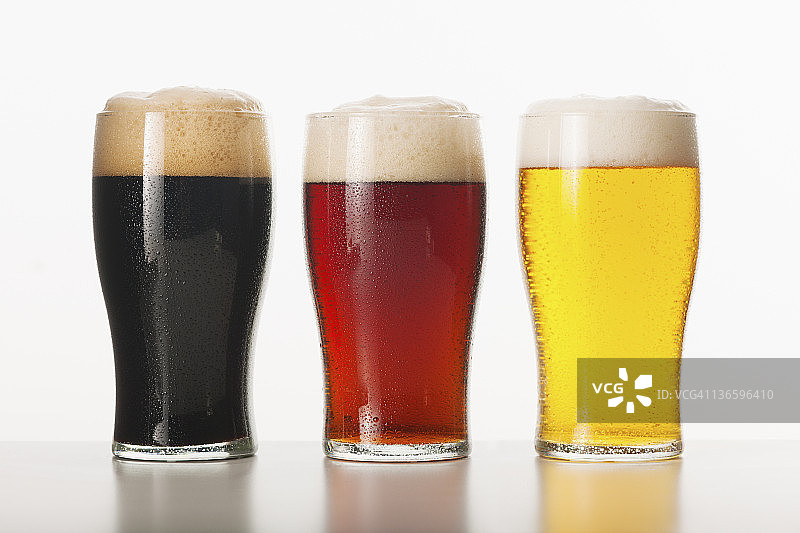 三杯装在玻璃杯里的啤酒，照相馆拍摄的图片素材