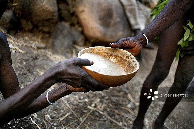 喀麦隆科马，Moltes Alantika，土著妇女将盛有汤的碗递给另一名妇女图片素材