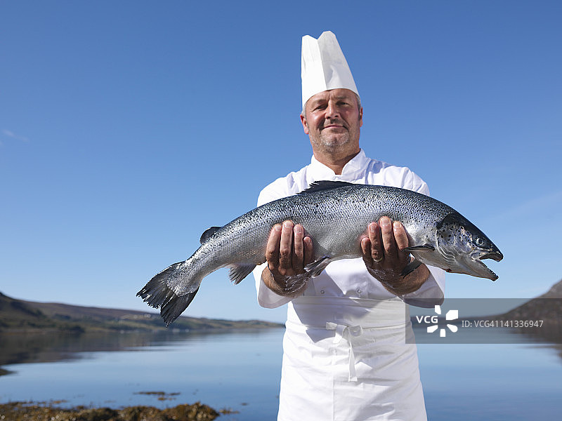 画像厨师拿着新鲜捕获的鲑鱼湖图片素材