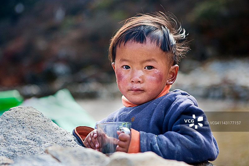 尼泊尔男孩喝着奶茶。图片素材