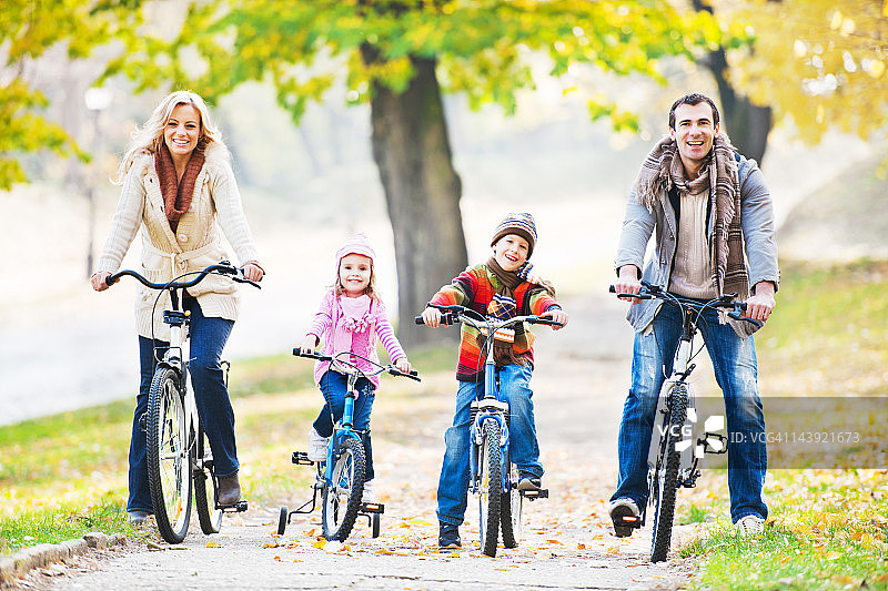 快乐家庭在大自然中骑自行车。图片素材
