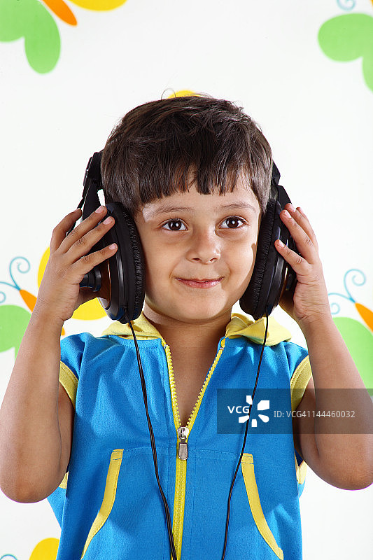 男孩戴着耳机听音乐图片素材