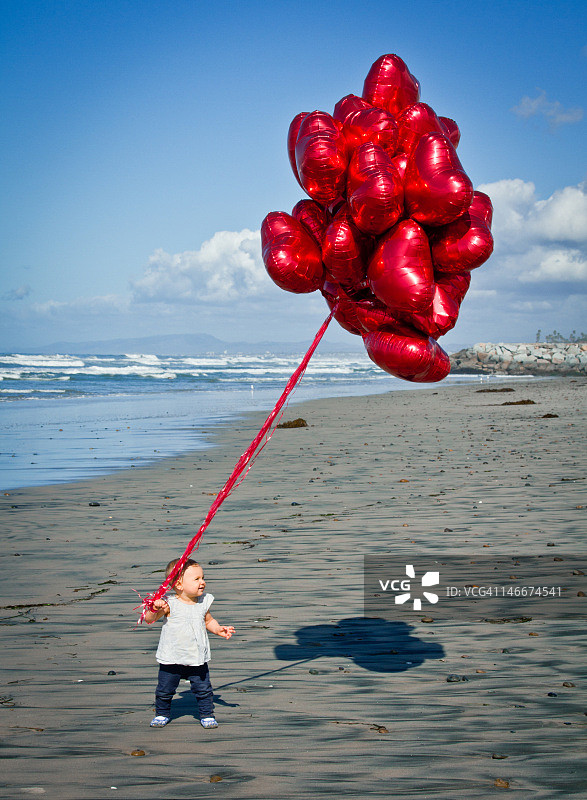 沙滩上的女孩拿着气球捧花图片素材