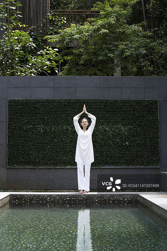 女人站在泳池边瑜伽姿势图片素材