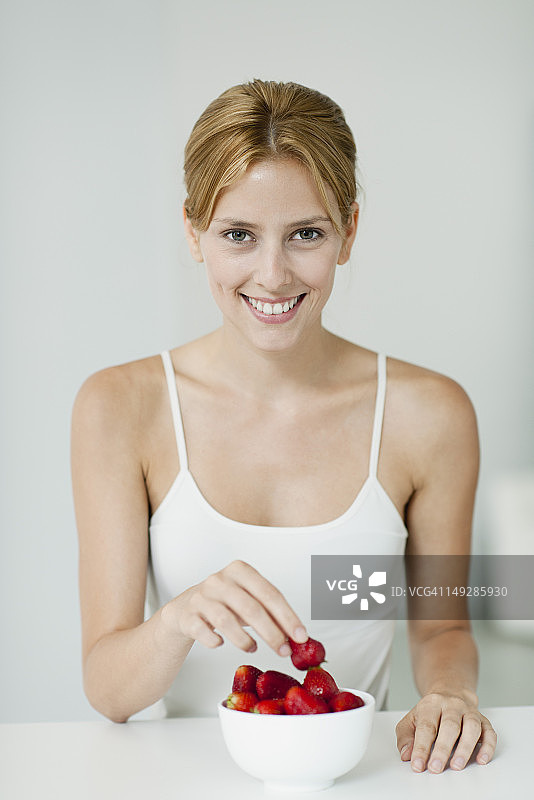 年轻女子端着一碗草莓图片素材