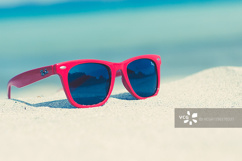 阳光沙滩上的红色太阳镜图片素材