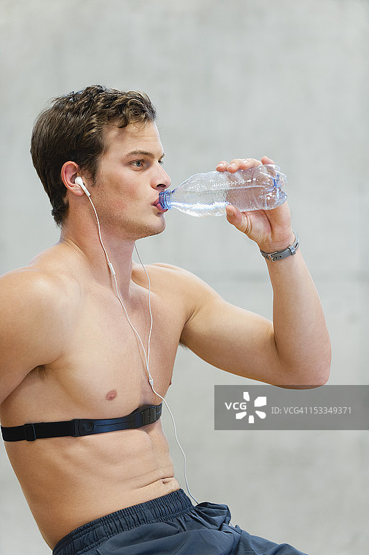 喝瓶装水的裸胸青年图片素材