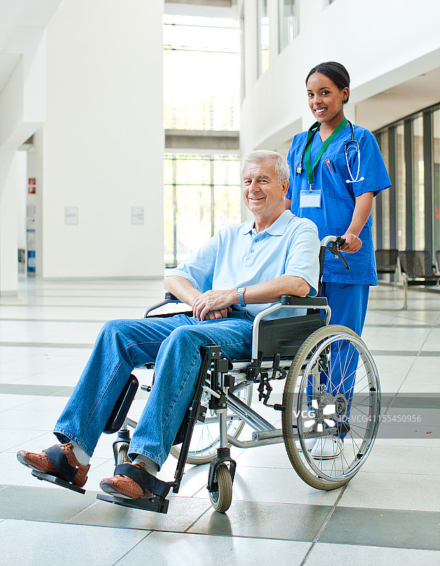 护士在帮助一个坐轮椅的病人图片素材