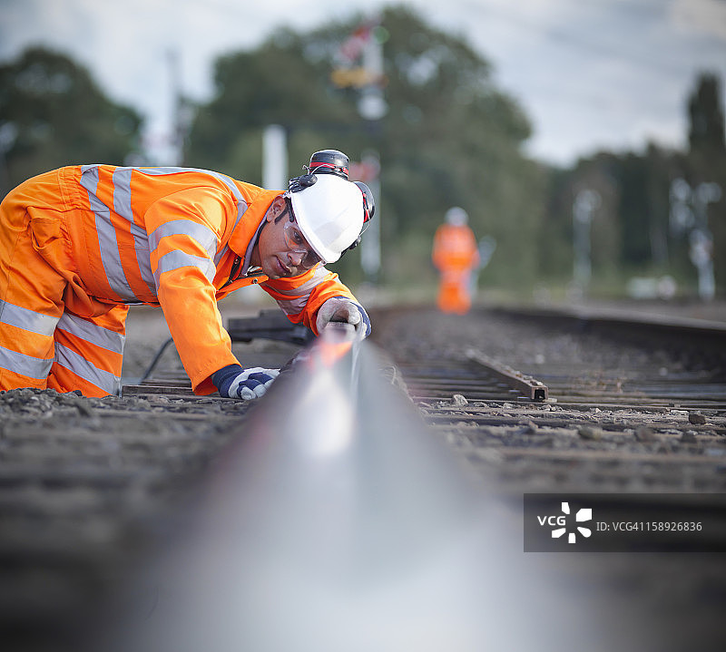 铁路工人检查铁路轨道水平，表面水平视图图片素材
