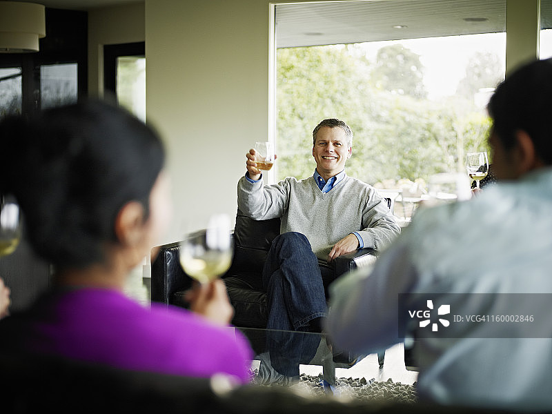 成熟的男人在客厅里祝酒图片素材