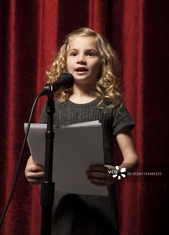 美国，犹他州，奥勒姆，女孩的肖像(8-9)用麦克风唱歌图片素材