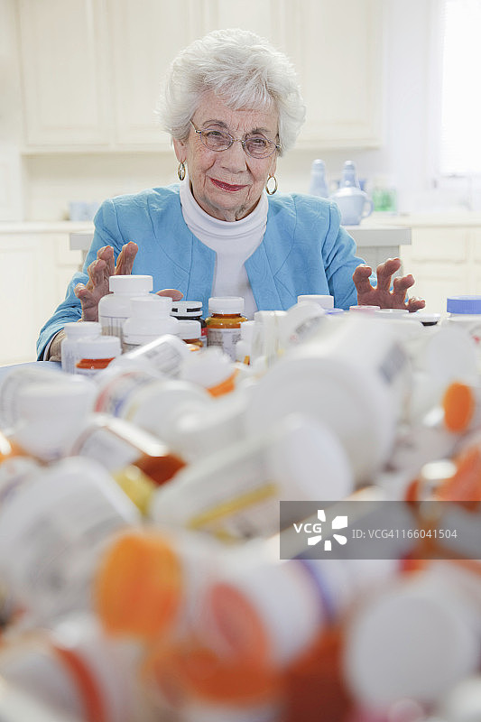 有一堆药瓶的老女人图片素材
