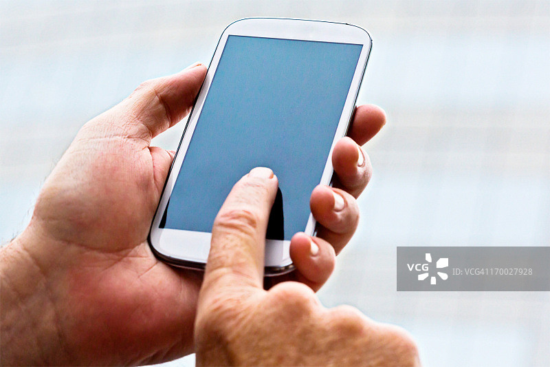 男性用手轻触智能手机的空白触摸屏图片素材