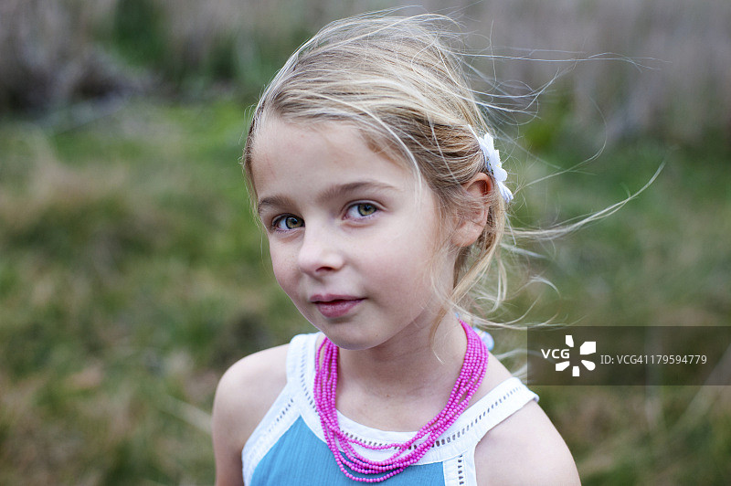 一个戴着粉色项链的年轻女孩的肖像。图片素材