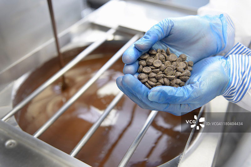巧克力工人在巧克力工厂检查巧克力片，特写图片素材
